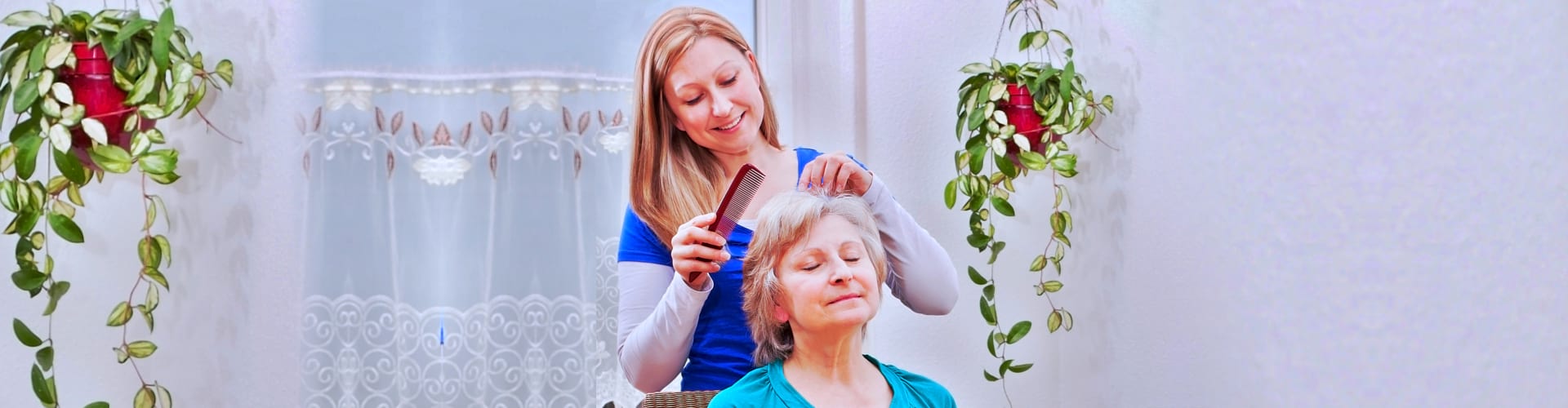 Blond young women combing seniors hair